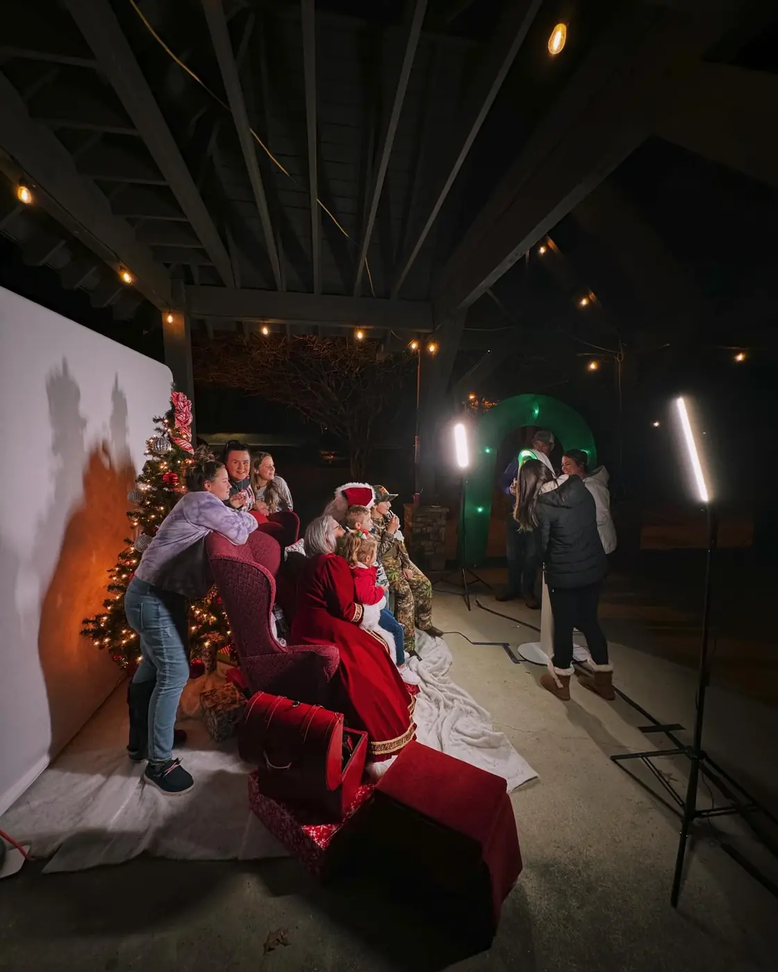 Family photographed with Santa at an outdoor evening holiday photo booth