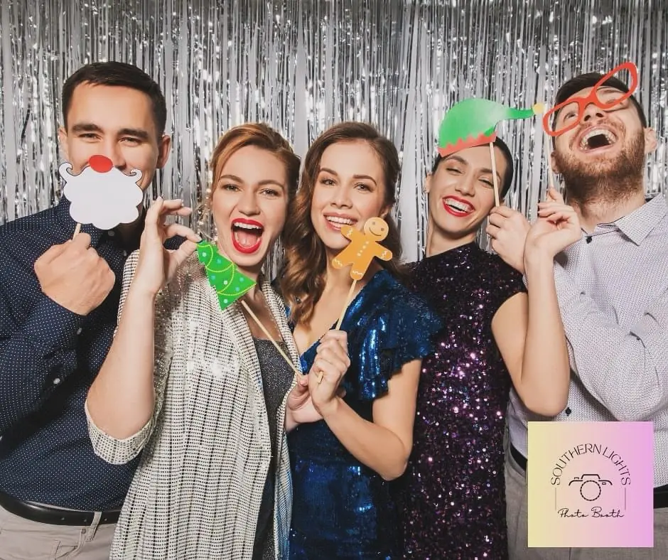 Friends holding holiday props in front of a silver fringe backdrop