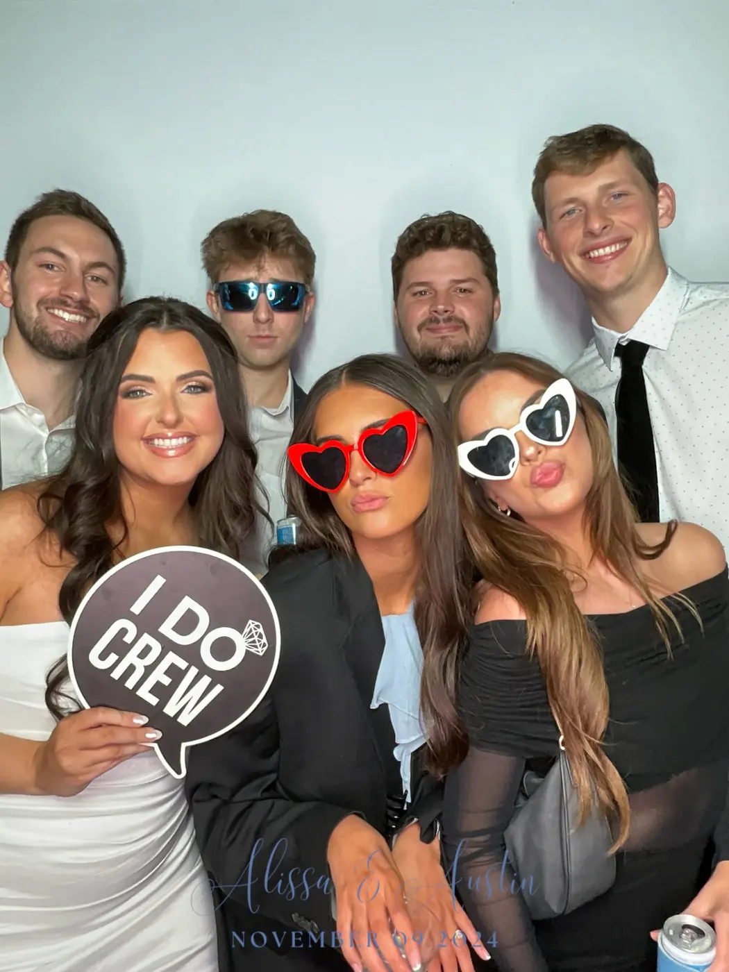 Wedding party posing with 'I Do Crew' sign in the photo booth